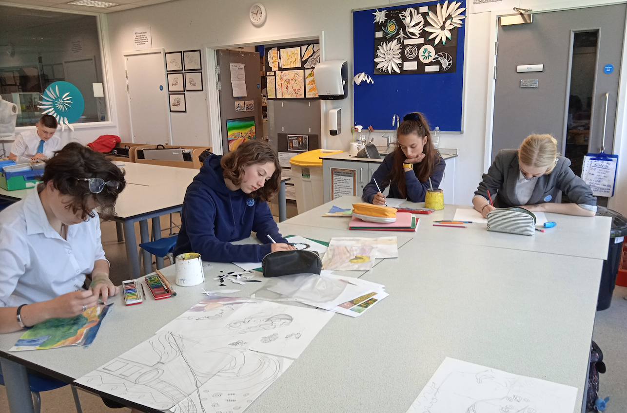 four students work on drawings