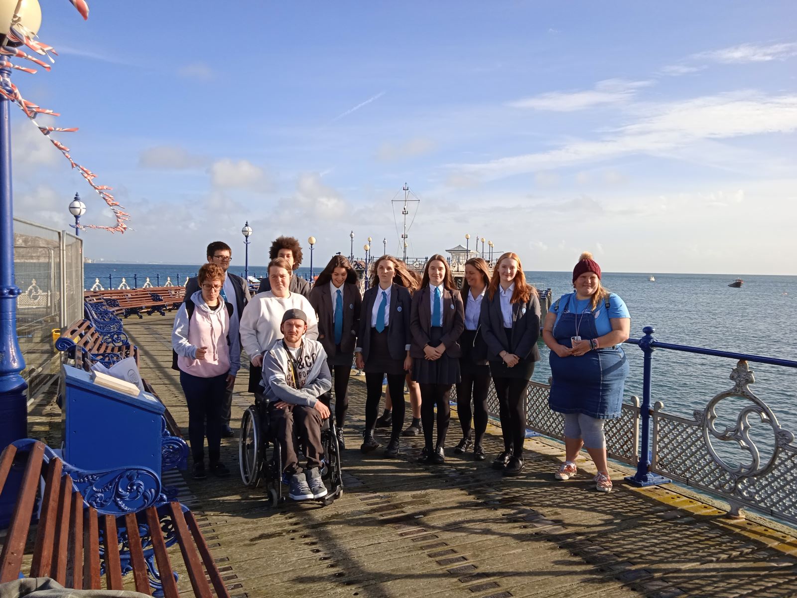 Group including students and young adults pose standing on Swanage Pier
